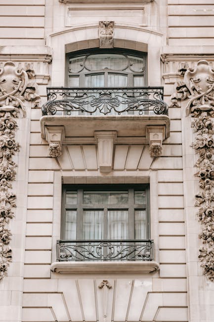 Aged masonry building exterior with fenced balconies and decorative beige walls in city in daylight