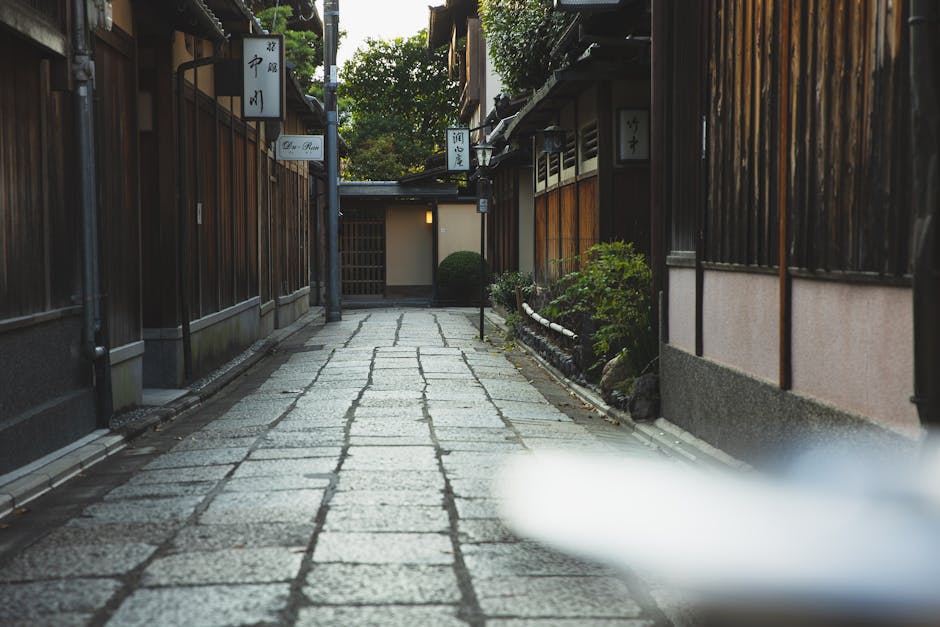 Explore a serene alleyway in Kyoto, Japan, showcasing traditional wooden architecture and cultural heritage.