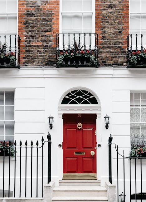 Exterior of aged residential house with red door decorated with lanterns and potted plants